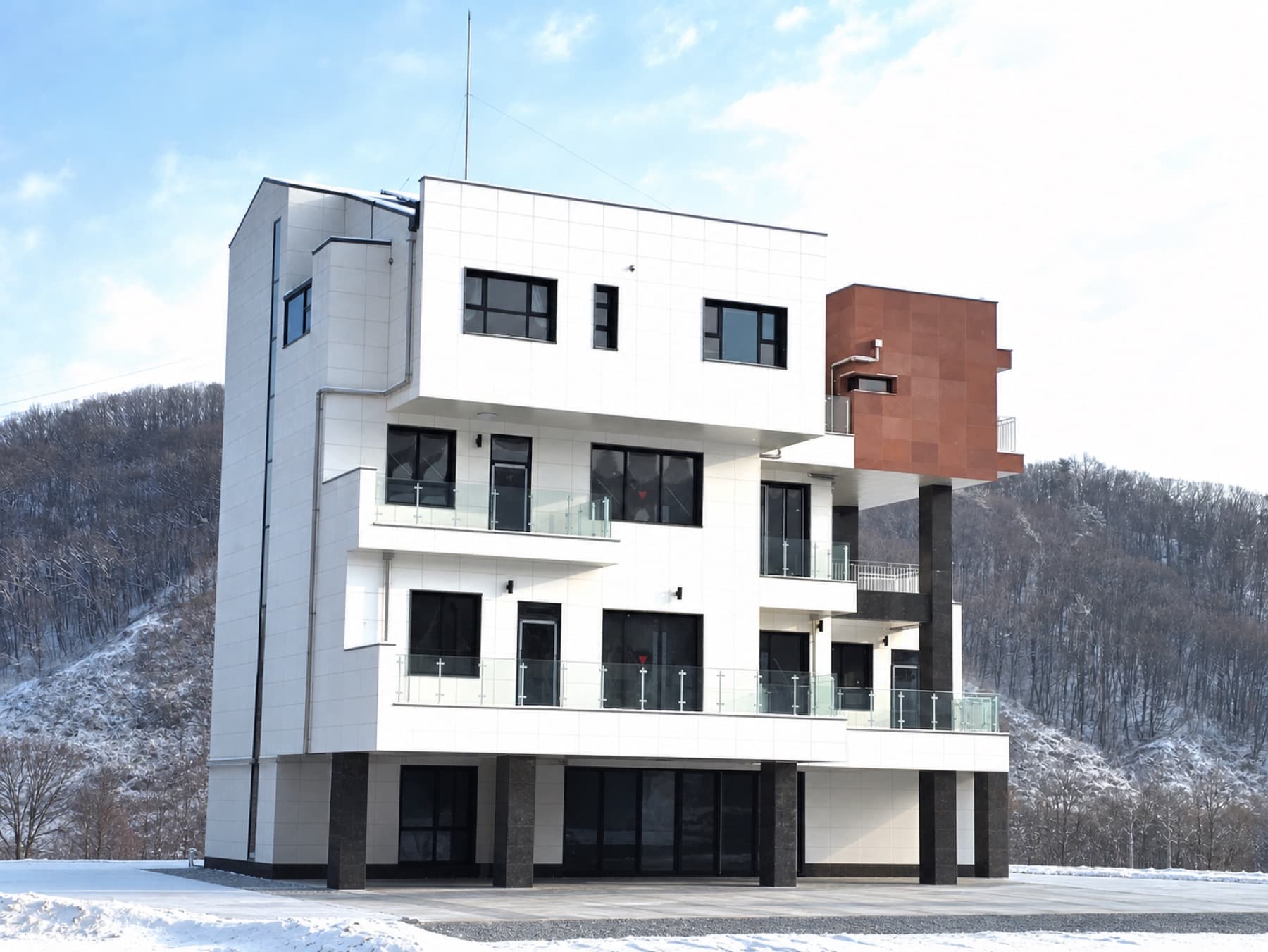 눈 쌓인 산을 배경으로 보이는 Gogi Lake Space 겨울 외관